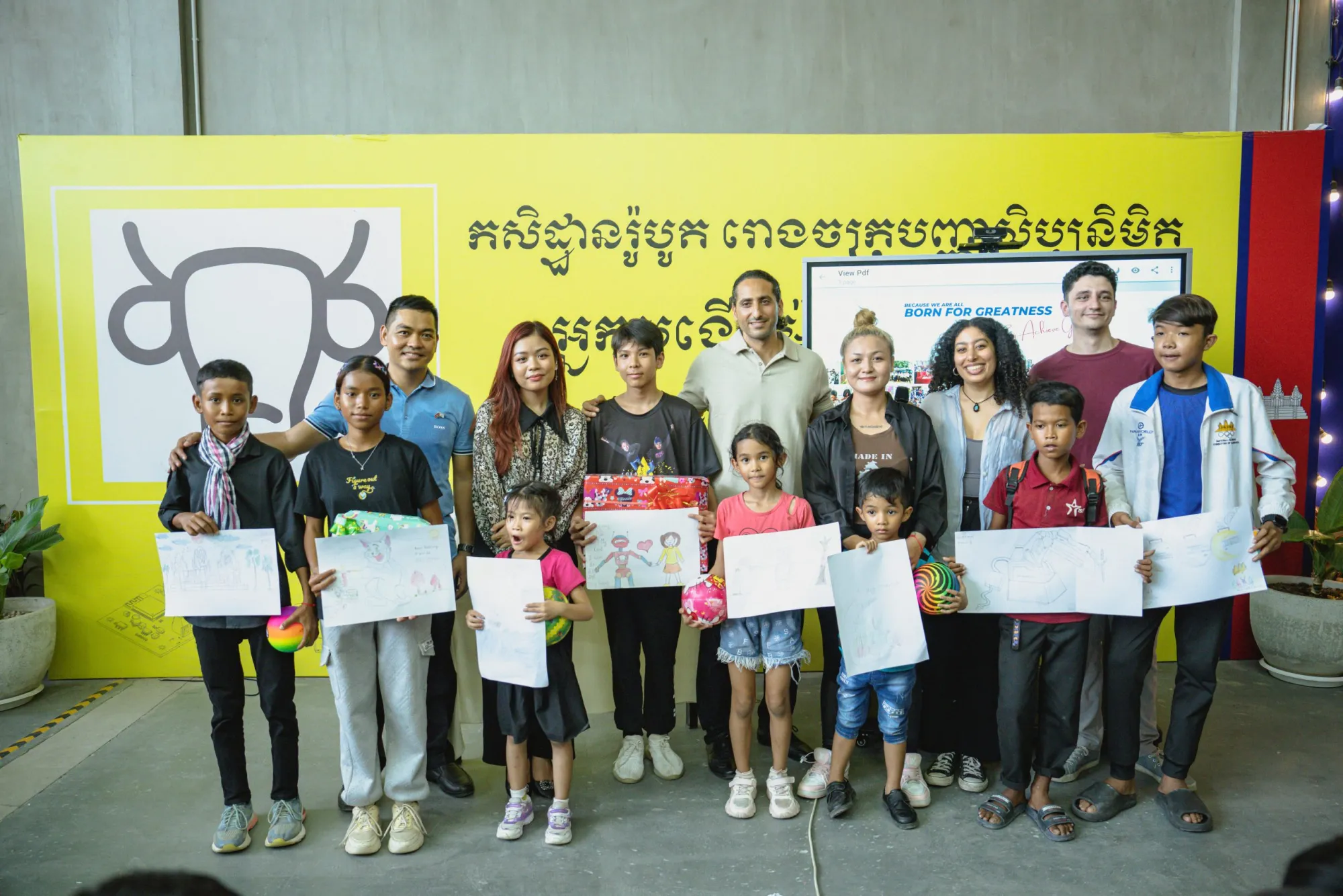 Group photo with children holding drawings